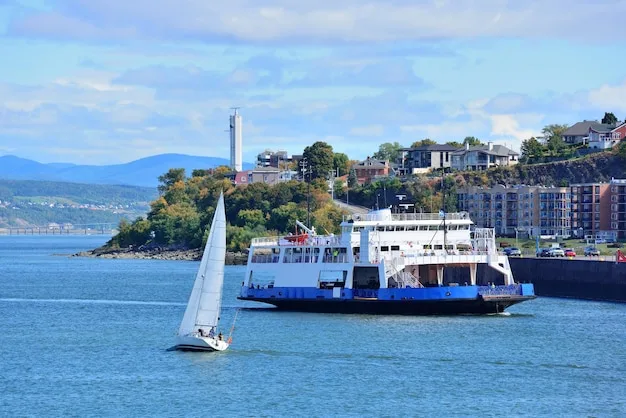 A white passenger ferry and a small sailboat on blue water below a wooded hillside
